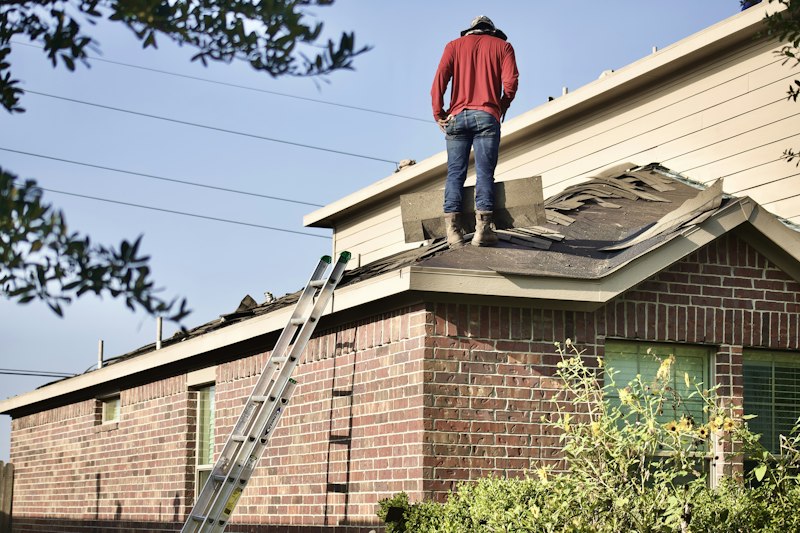 Roof with storm-damaged shingles before repair